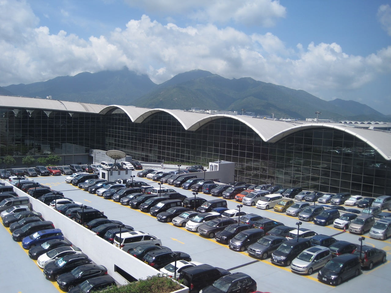 a parking lot with cars and a mountain in the background