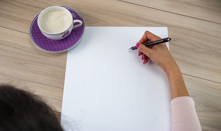 a person applying makeup on a white sheet of paper