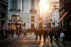 a group of people walking down a street with buildings on either side