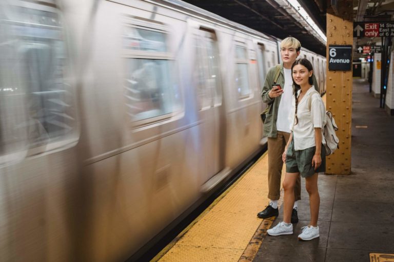 a man and a woman standing next to a train