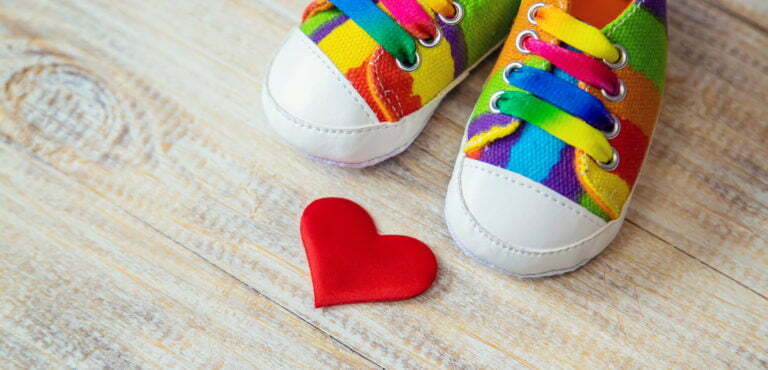 Baby booties and heart on a light background. Selective focus.