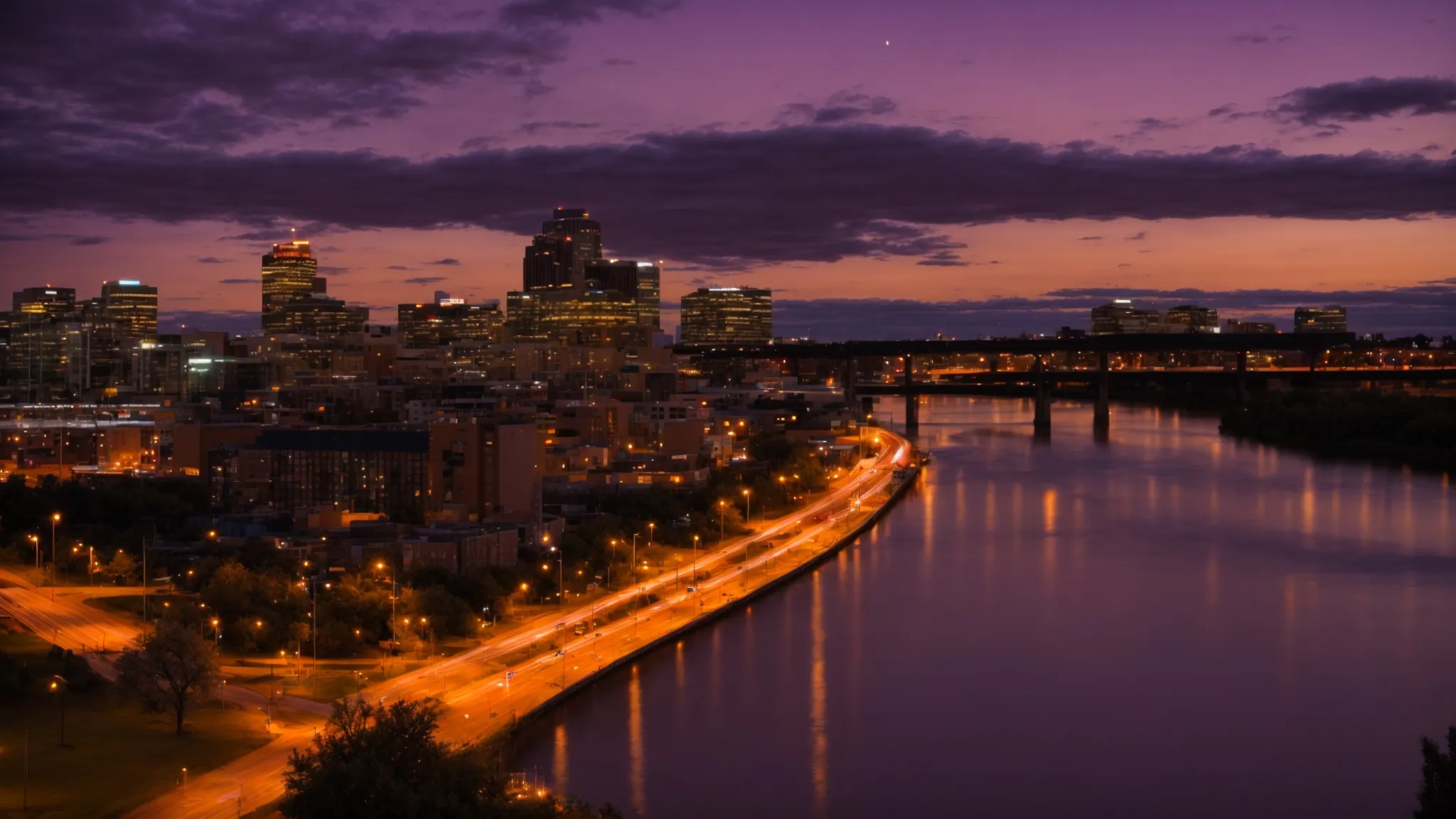 a vibrant sunset dipping below the silhouette of saskatoon's cityscape along the riverbank.