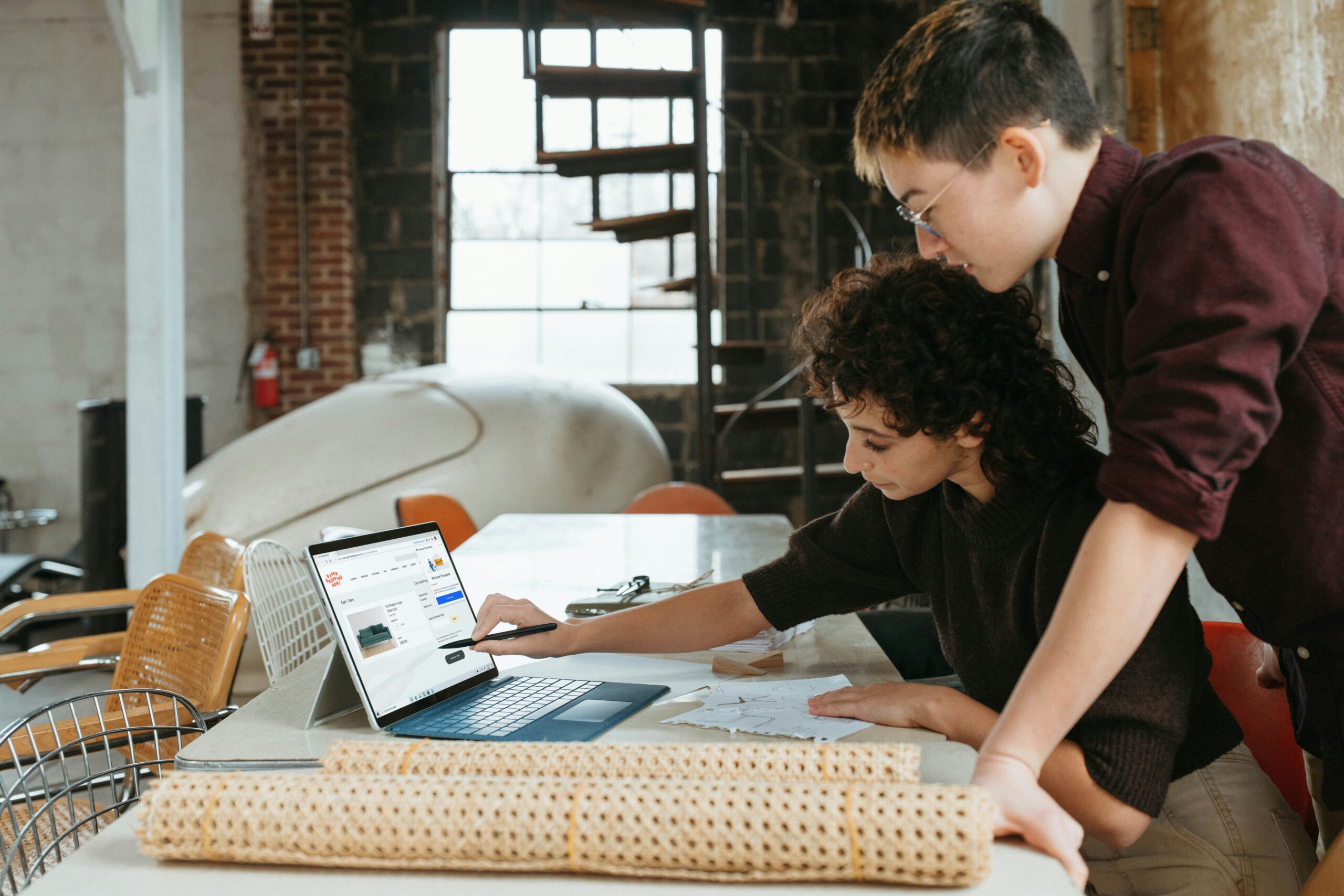 a man showing a woman something on the laptop